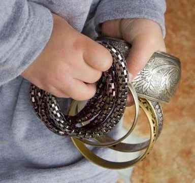 Bracelets in a child's hands Stock Photos