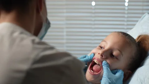 Braces for child teeth correction. Dentist checking little girl teeth retai.. Stock Footage 289828435