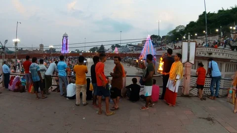 Brahmin with fire seeks pilgrims and tourists on the evening bridge over the Gan Stock Footage 107558386