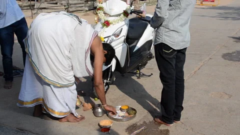 A Brahmin performs a religious ritual over a motorcycle. Stock Footage 301409367