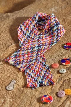 A braid of multi colored sewing threads, needle, needle threader, buttons Stock Photos