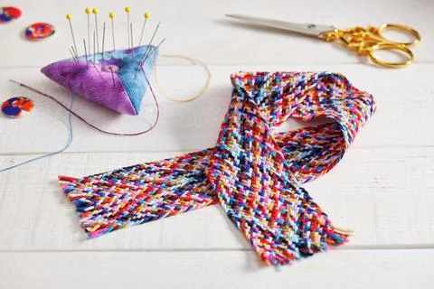 A braid of multi colored sewing threads, pincushion, scissors, buttons Stock Photos