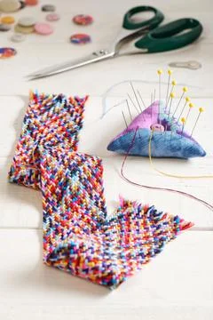 A braid of multi colored sewing threads, pincushion, scissors, needle threade Fotos de archivo