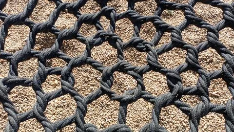 Braided cells web of black thick rope The central part of the swing for children Foto stock