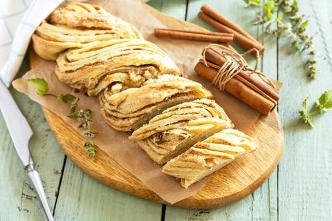 Braided cinnamon sweet bread on rustic wooden board with cinnamon sticks an.. Stock Photos