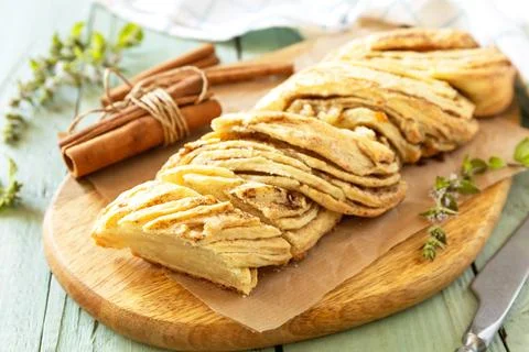 Braided cinnamon sweet bread on rustic wooden board with cinnamon sticks an.. Stock Photos