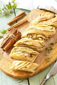 Braided cinnamon sweet bread on rustic wooden board with cinnamon sticks an.. Stock Photos