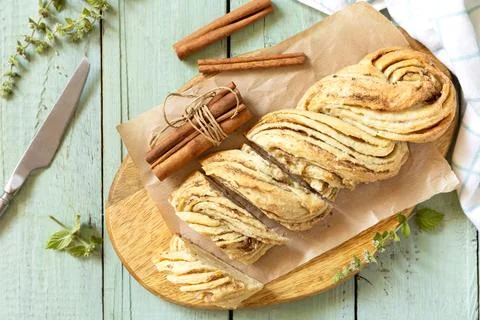 Braided cinnamon sweet bread on rustic wooden board with cinnamon sticks an.. Stock Photos