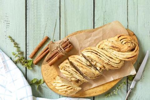 Braided cinnamon sweet bread on rustic wooden board with cinnamon sticks an.. Stock Photos