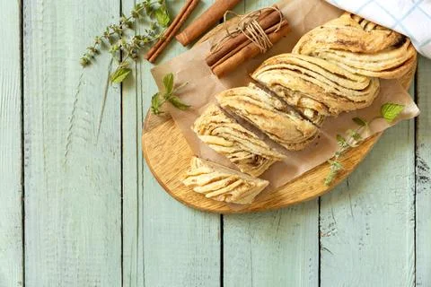 Braided cinnamon sweet bread on rustic wooden board with cinnamon sticks an.. Stock Photos