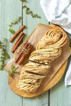 Braided cinnamon sweet bread on rustic wooden board with cinnamon sticks an.. Stock Photos