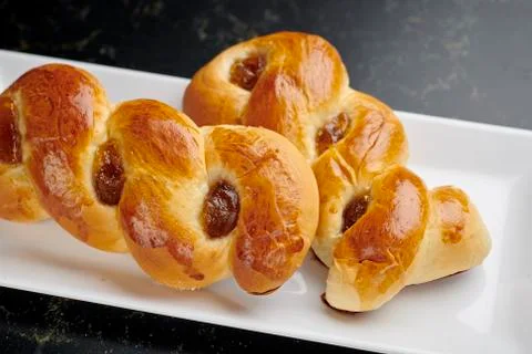 Braided marmalade brioches on a white rectangular plate Foto stock