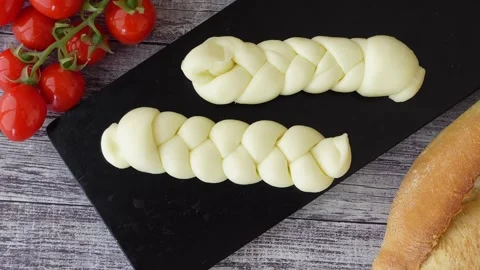 Braided soft cheese with tomatoes and bread Stock Footage 311795053