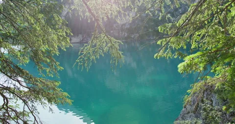 Braies Lake framed by pine branches in the Dolomites Stockbeeldmateriaal 340790656