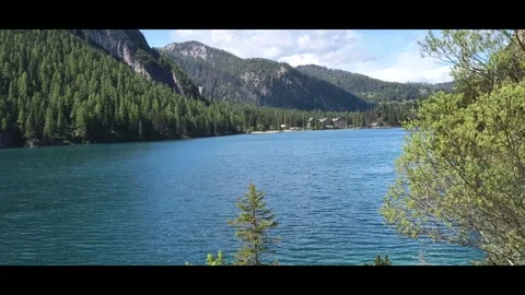 Braies Lake with pine forest and peaks, panning left, wide shot Video stock 313351168