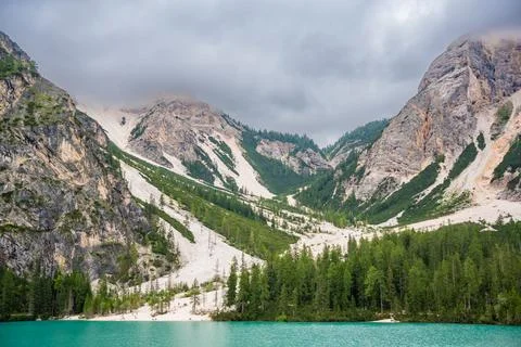 Braies lake surrounded by pine forests and the rocky ranges of the Dolomites in Stock Photos