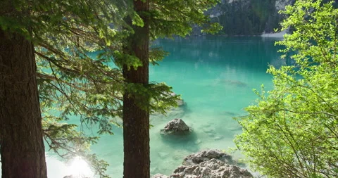 Braies Lake through forest trees in the Dolomites Stock Footage 340790183