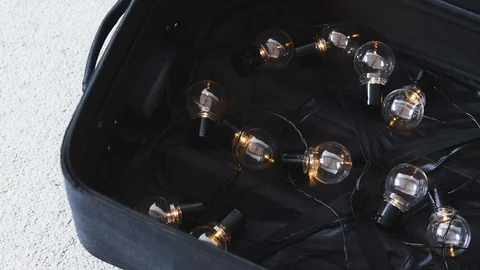 Brain drain concept, open suitcase with string of lightbulbs switched on symb Stock Footage 123741850