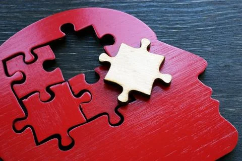 Brain problems or mental illness. The shape of a human head with a puzzle piece. Stock Photos