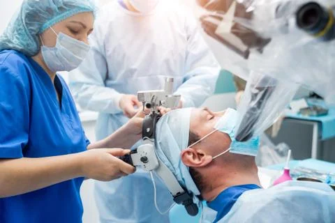 Brain surgery. Group of surgeons in operating room with surgery equipment. Stock Photos