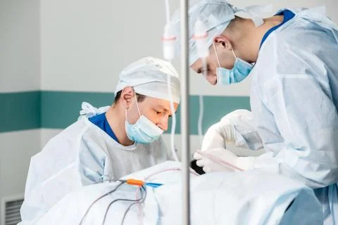 Brain surgery. Group of surgeons in operating room with surgery equipment. Stock Photos