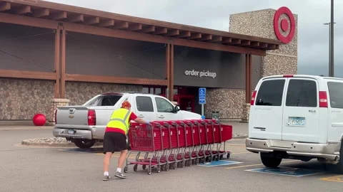 BRAINERD, MN - 16 JUL 2025: Employee pushing shopping carts Stock Footage 319909813