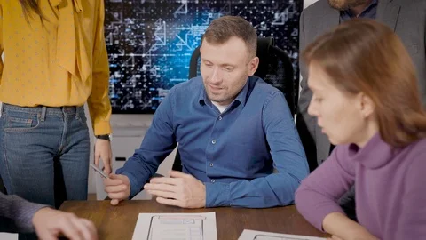 Brainstorm. The development team is discussing the layout of the mobile Stock-Footage 120013959