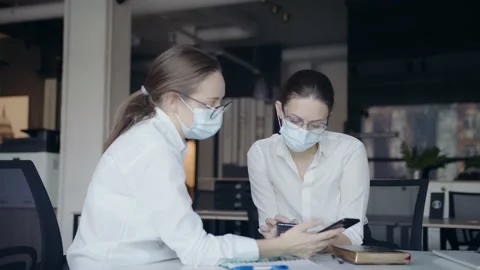 Brainstorm a small creative team wearing protective masks. Business women Stock Footage 145075134