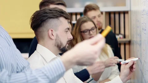 Brainstorming in the office. Colleagues discuss the problem and make notes on a Stock Footage 103939682