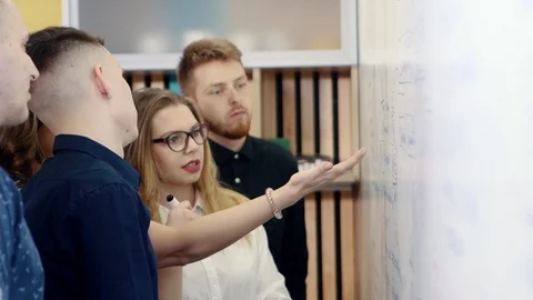 Brainstorming in the office. Colleagues discuss the problem and make notes on a Stock Footage 104668025