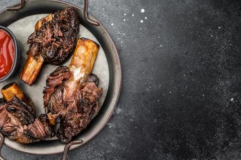Braised beef ribs with pulled texture and caramelized surface in pan. Slow .. Stock Photos