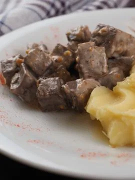 Braised beef in sauce and mashed potatoes on a white plate Stock Photos