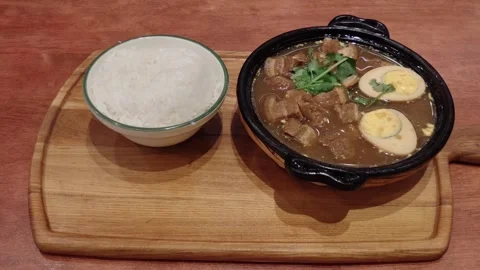 Braised pork belly with soy-marinated eggs served in a clay pot with rice 库存影片 339116884