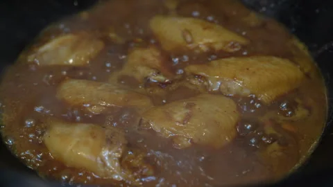 Braising chicken wings in wok Stock Footage 329557828
