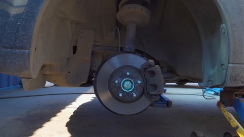 Brake disk and car jack in a car auto service Stock Footage 107153797