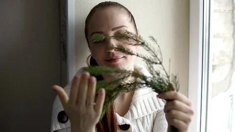 Branch of the Christmas tree in the hands of a middle-aged woman Stock Footage 99726929