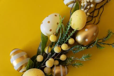 Branch with Easter eggs on a yellow background. Happy Easter with place for t Stock Photos