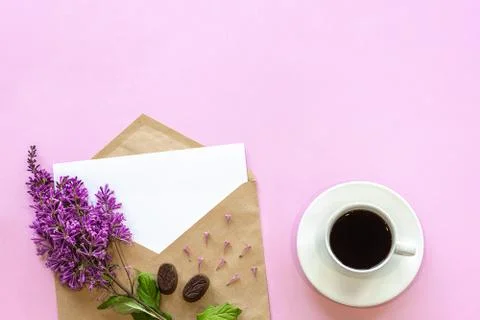 Branch of lilac on craft envelope with empty card and coffee Stock Photos
