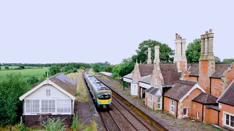 Branch line train passing a disused station Stock Footage 247399245