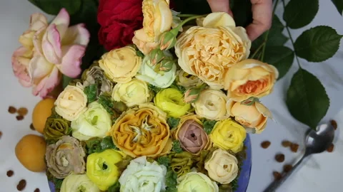 A branch of a live yellow rose is placed on the cake. The pastry shop is decorat Stock Footage 143676136