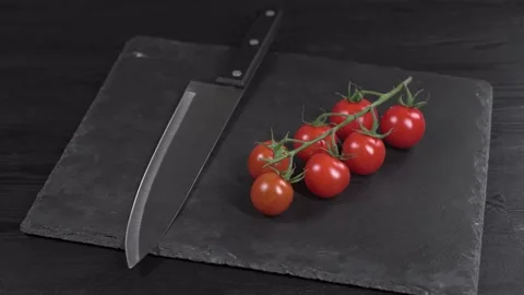 Branch tasty red cherry tomatoes and washed steel chefs knife shiny reflections Stock Footage 149003528
