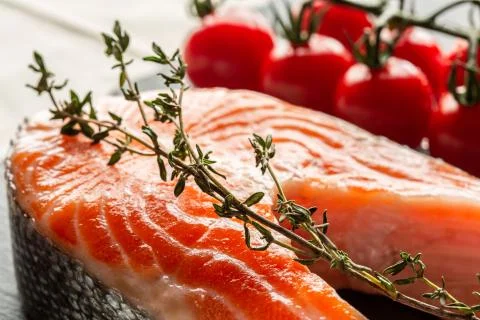 Branch of thyme placed on the slice of raw red fish Stock Photos