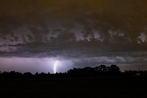 Branched lightning strike under low dramatic clouds 库存照片