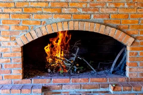 Branches are burning inside fireplace made of bricks Stock-Fotos