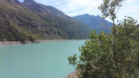 Branches of a tree rustling above Lake Place Moulin (Aosta Valley) 스톡 동영상 331521974
