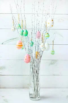 The branches of the trees decorated with multi-colored Easter eggs stand Stock Photos