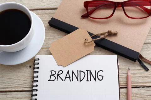 Branding concept with notebook brand tag and glasses on work desk Stock Photos