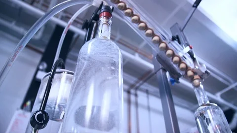 Brandy bottle being filled by hose at distillery during bottling Stock Footage 87121768