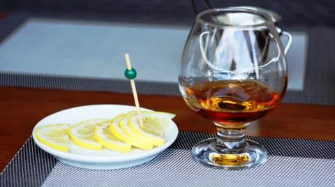 Brandy with lemon. Stock Photos