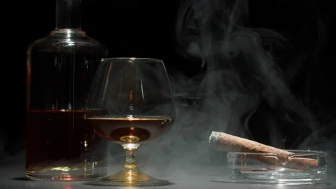 brandy cigarette Brandy or whiskey and cigar close-up. Smoking cigarette and drinking luxury